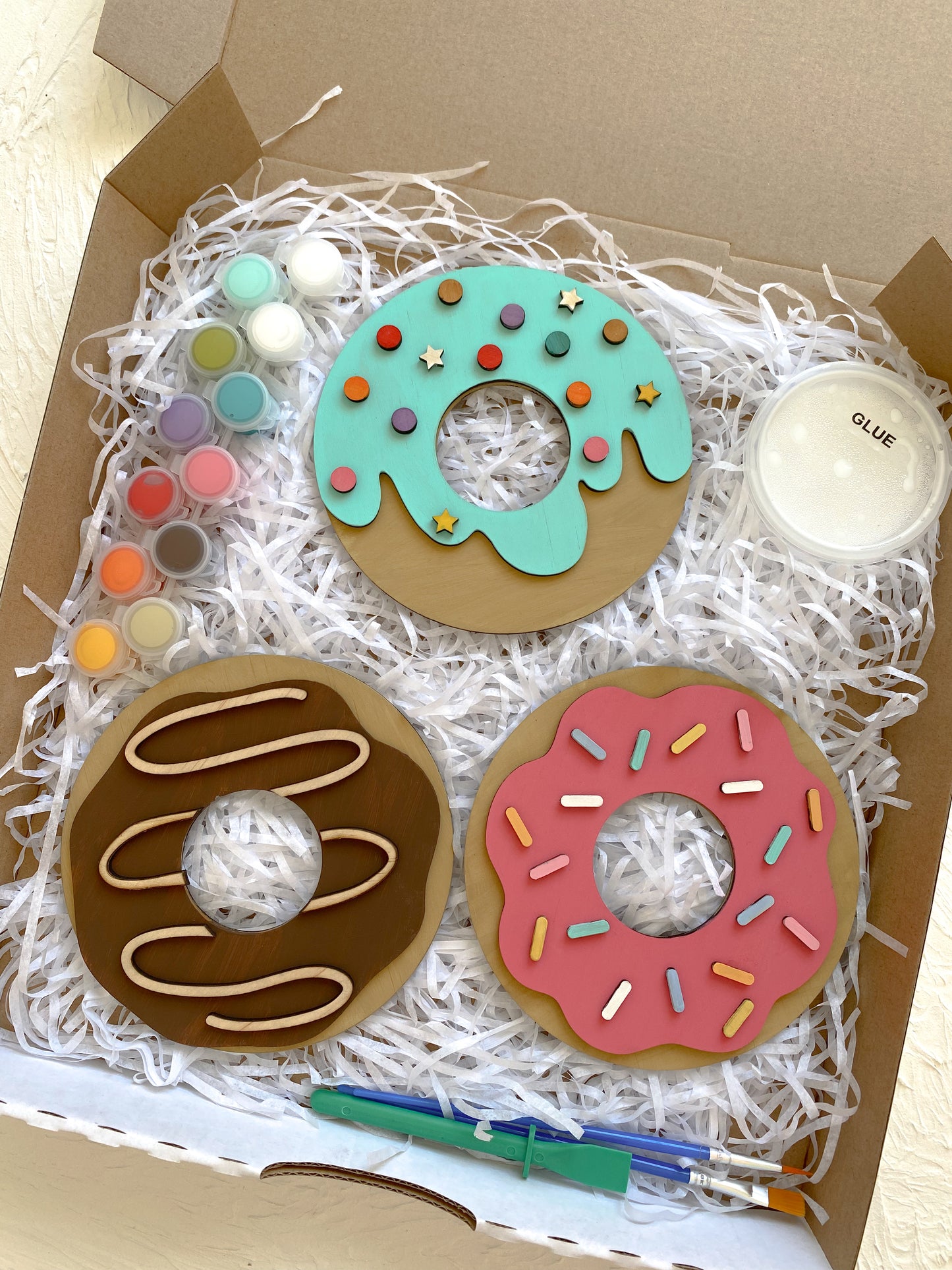 Donut-shaped art project with paint supplies in a box